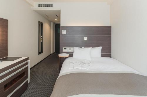 Postel nebo postele na pokoji v ubytování Kusatsu Estopia Hotel
