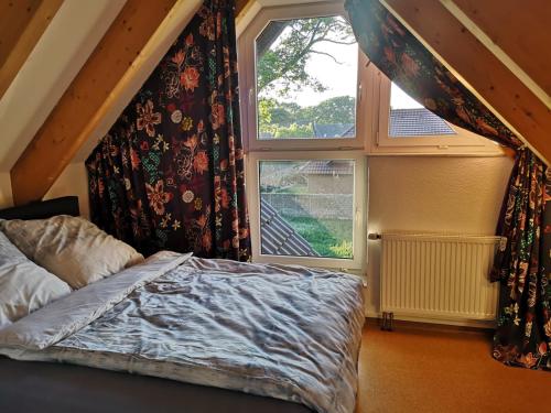 Schlafzimmer mit einem Bett und einem Fenster in der Unterkunft Ferienloft Dalum in Geeste