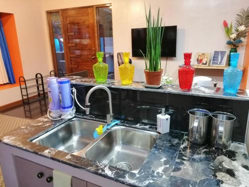 a kitchen counter with a sink and colorful vases at Blue Residence Tagaytay in Tagaytay