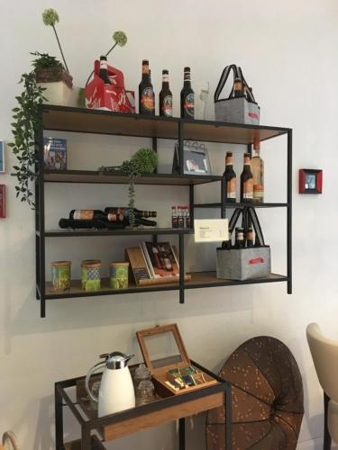 a shelf with bottles on a wall with a table at Gaestehaus Klaus in Mendig