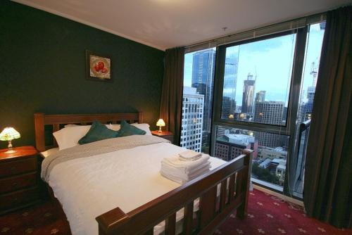 - une chambre avec un lit et une grande fenêtre dans l'établissement CityPoint - Melbourne, à Melbourne