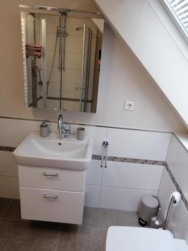 a bathroom with a sink and a mirror at Ferienwohnung Hafenliebe-Greetsiel in Greetsiel