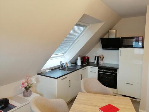グレートジールにあるFerienwohnung Hafenliebe-Greetsielのシンクとコンロのある小さなキッチン