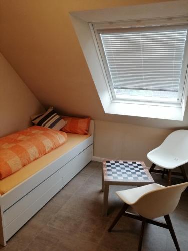 a attic bedroom with a bed and a window at Ferienwohnung Hafenliebe-Greetsiel in Greetsiel