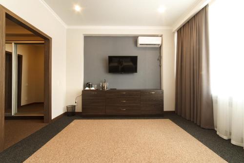 a room with a dresser with a television on the wall at Meridian in Karagandy