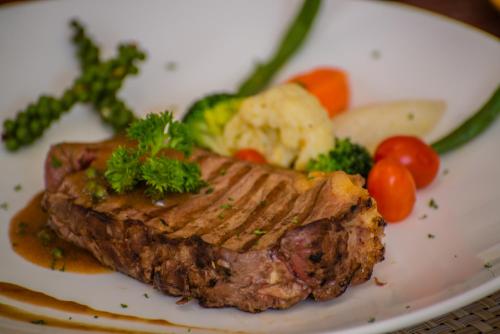 a plate of food with meat and vegetables on it at Cambana Residence in Siem Reap