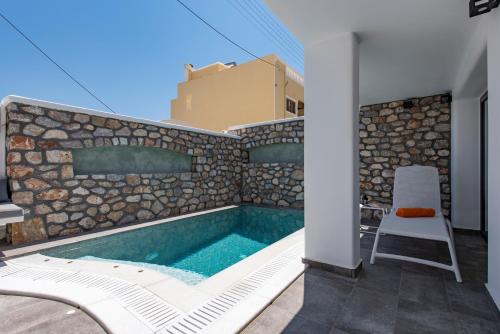 a swimming pool with a chair next to a building at Aurum in Kamari