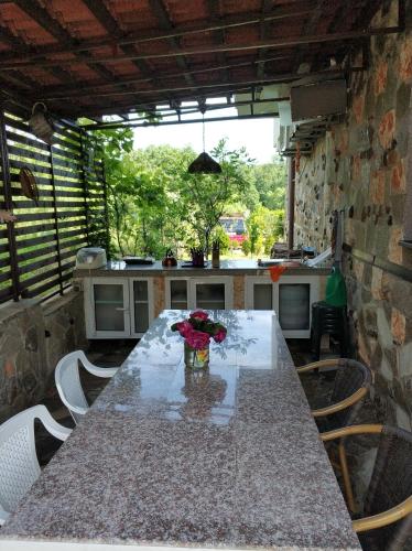 a kitchen with a long table with flowers on it at Zapovedni Rai in Primorsko