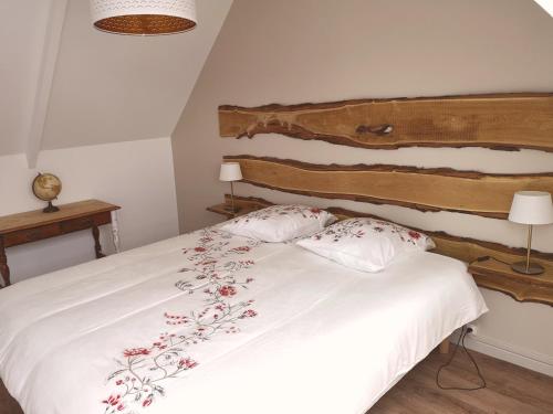 um quarto com uma cama branca com flores vermelhas em Les bulles champenoises em Châtillon-sur-Marne