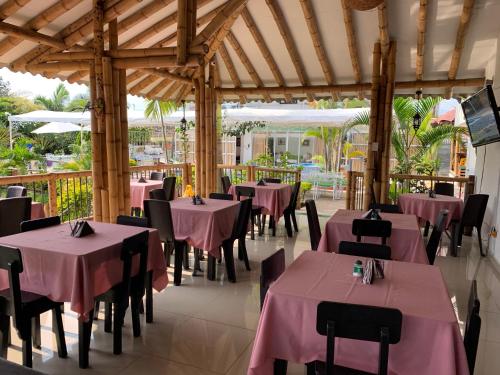 a restaurant with tables and chairs with pink tablecloths at Hotel West California in Armenia