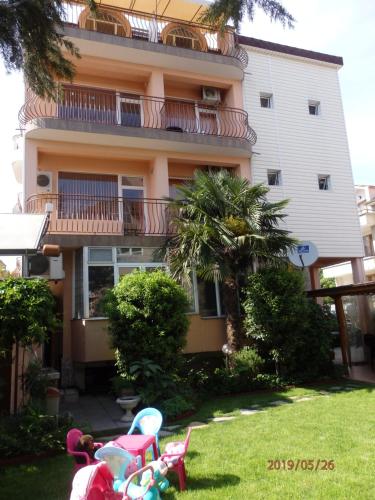 a house with a yard with chairs in front of it at Guest house Napoli in Ravda