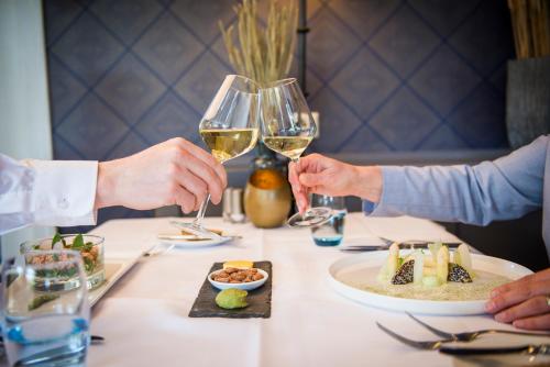 two people sitting at a table with glasses of wine at Hotel Greenside Texel in De Koog