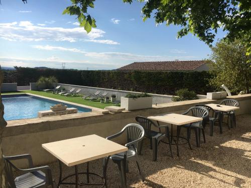 una fila di tavoli e sedie accanto alla piscina di DOMAINE FORVENT a Saint-Julien-de-Peyrolas