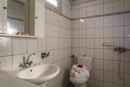 a white bathroom with a sink and a toilet at Neptune in Alonnisos Old Town