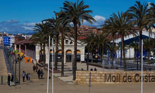 a group of palm trees in a city with a building at Tarragona Ciudad, El Serrallo AP-1 in Tarragona