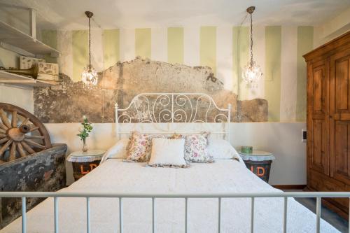 a bedroom with a white bed with two pillows at B&B Rosso Baccara in Montevettolini