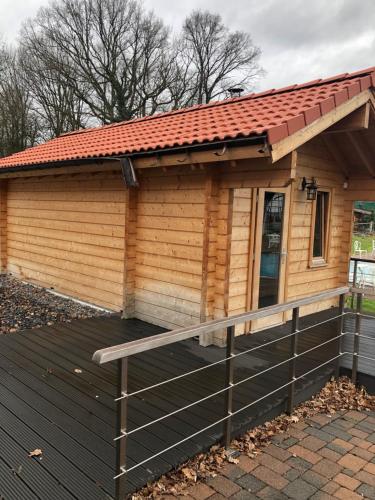 a small wooden cabin with a red roof at Hotel & Gastropark Loemühle in Marl
