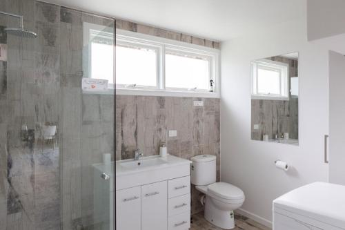 a bathroom with a toilet and a glass shower at Sandy point hideaway in Sandy Point