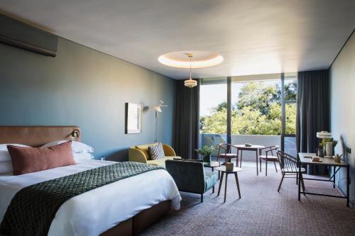 a hotel room with a bed and a table and chairs at Home Suite Hotels Rosebank in Johannesburg