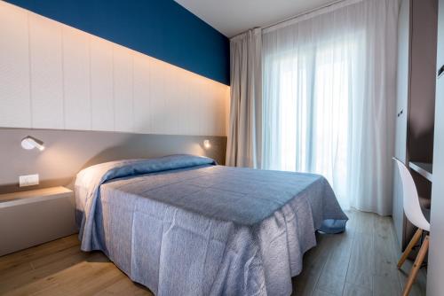 a bedroom with a bed and a large window at Hotel Relax Family & Spa in San Benedetto del Tronto