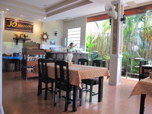 a dining room with a table and chairs in a restaurant at MJ Boutique Hotel Khao Lak in Khao Lak