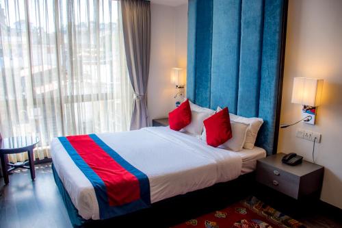 a bedroom with a large bed with red and blue accents at M Hotel Thamel-Kathmandu in Kathmandu