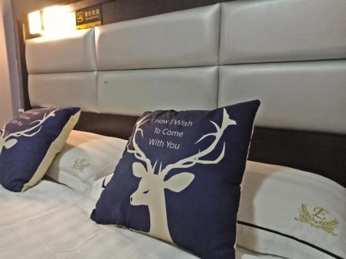 a bed with two pillows with a deer on it at T Hotel Johor Bahru in Skudai