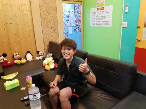 a young man sitting on a couch giving a thumbs up at Checheng Backpackers Hostel in Checheng