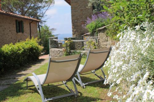 two chairs sitting in the grass in a garden at Podere I Rovai-apt IL RIFUGIO- in the heart of Tuscany in Reggello
