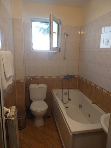 a bathroom with a toilet and a tub and a sink at Hotel Tsarevets in Asenovgrad