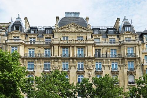 
a large building with a clock on the front of it at Fraser Suites Le Claridge Champs-Elysées in Paris

