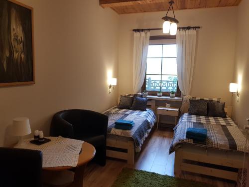 a room with two beds and a desk and a window at Kosiedlisko in Kraśnik