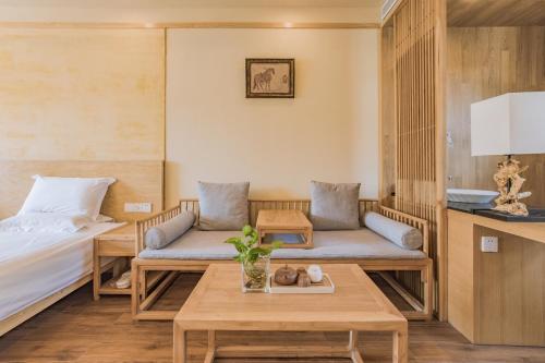 a room with couches and a table and a bed at Hangzhou Van Wind Inn in Hangzhou