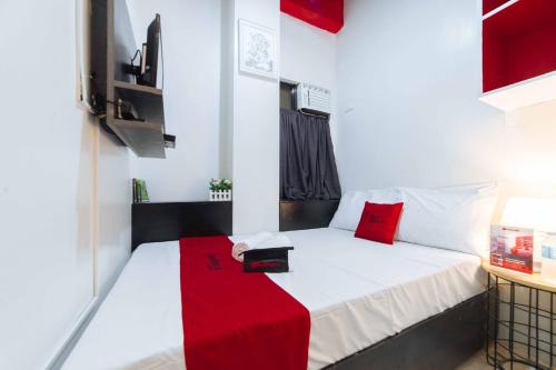 um pequeno quarto com uma cama com um cobertor vermelho em RedDoorz near G Mall Bajada- Multiple Use Hotel em Davao