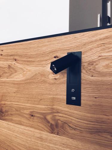 a black electrical outlet on a wooden desk at Fritz Lauterbad in Freudenstadt