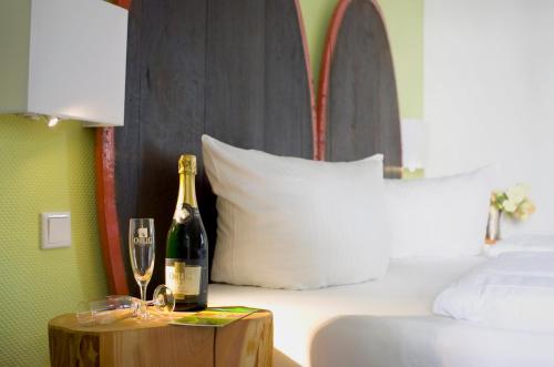 a bottle of champagne on a table next to a bed at Hotel Lindenwirt in Rüdesheim am Rhein