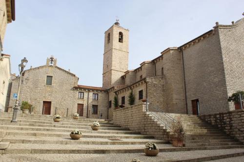 a building with stairs and a clock tower on it at La Vecchia Posta B&B in Calangianus