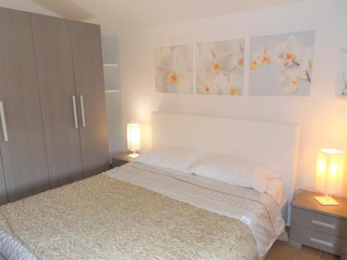 ein Schlafzimmer mit einem Bett und zwei Lampen an Tischen in der Unterkunft Casa Puccini in Garda