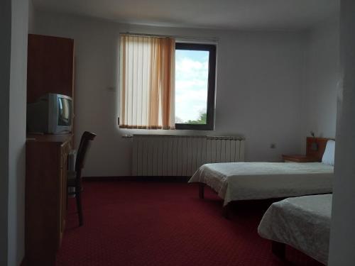 Habitación de hotel con 2 camas y TV en ХОТЕЛ НИК, en Asenovgrad