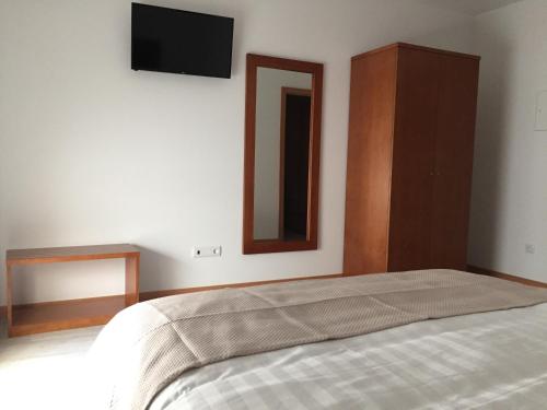 a bedroom with a bed and a tv on the wall at Quinta de Real in Valença