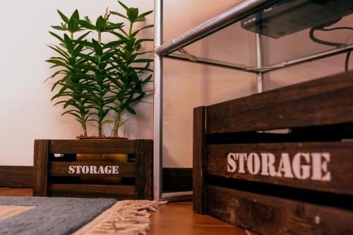 a plant in a wooden crate next to a bed at Apartment Bišćan Samobor in Samobor