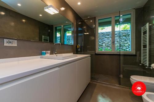 uma casa de banho com um lavatório, um WC e um espelho. em PARADISE LUXURY TERRACE em Portovenere