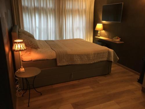 1 dormitorio con cama, mesa y ventana en Veld en Bosch, en Leusden
