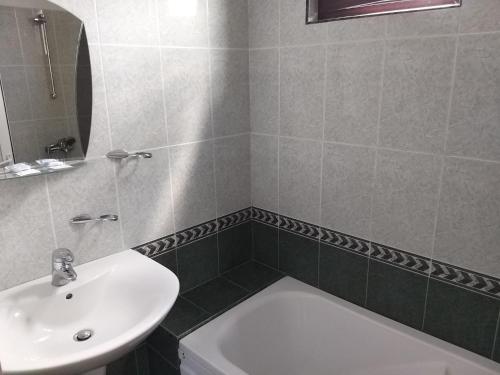 a bathroom with a sink and a toilet and a mirror at ХОТЕЛ НИК in Asenovgrad