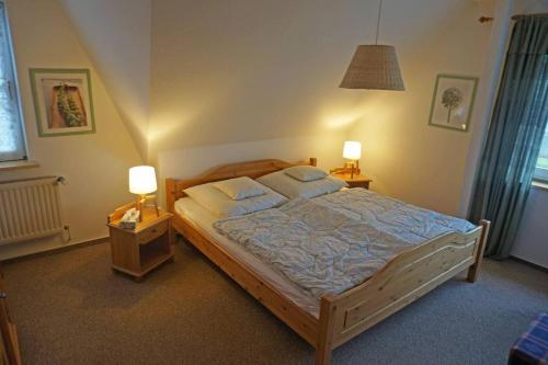 ein Schlafzimmer mit einem großen Bett mit zwei Nachttischen in der Unterkunft Ferienwohnung auf der Sonneninsel in Fehmarn