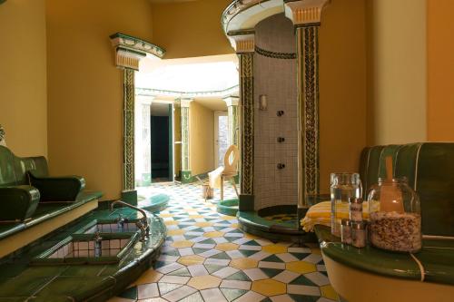 a lobby with green and yellow tiles and a room with a tub at Bei Max - Hotel Garni Kirchenwirt in Sankt Leonhard im Pitztal
