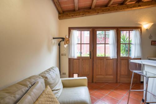 a living room with a couch in front of a door at B&B Rosso Baccara in Montevettolini