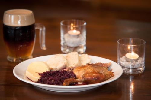 a plate of food on a table with two glasses of beer at Penzion V Údolí in Hodkovice nad Mohelkou