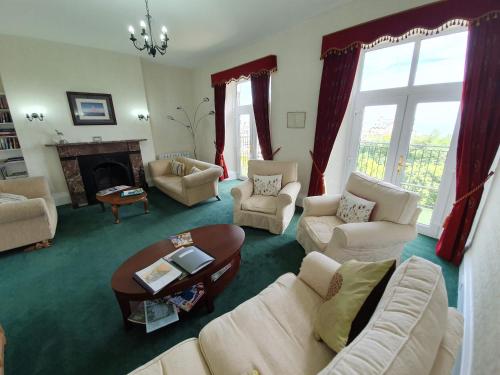 a living room with white furniture and a fireplace at Sinai House in Lynton