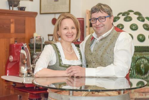a man and woman standing next to a glass table at Landhotel Pacher in Obervellach